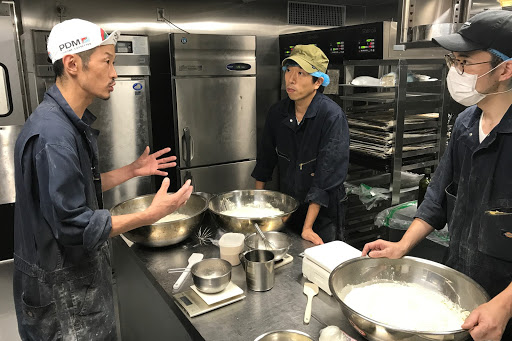 日々おいしいパン作りを探求し続けるパン職人の田中さん（写真左）