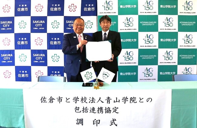署名済の協定書を掲げる西田三十五佐倉市長（左）、稲積宏誠青山学院大学学長（右）