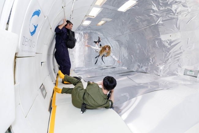 Wix写真コンテスト優勝者の若井玲子さんが無重力空間で宇宙服姿で宙に浮くスタヴ ストラスコを撮影する様子　提供元：Steve Boxell – ZERO-G