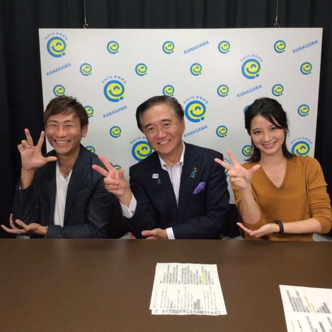 笑顔を見せる総合プロデューサーのクレイ勇輝と黒岩県知事