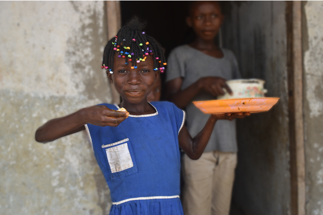NPO法人アラジが提供する学校給食を食べる、シエラレオネの女の子