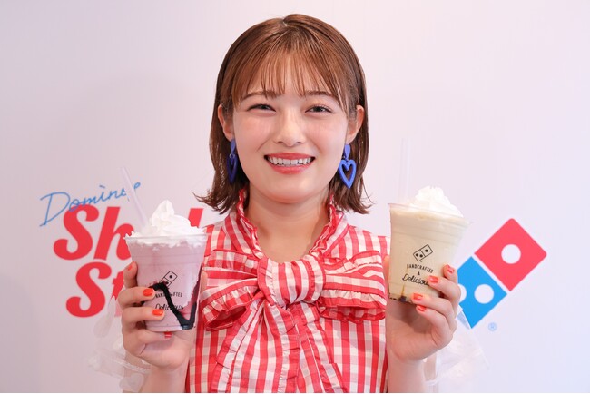 「ドミノシェイク カシス」を右手に持ち、 絶賛する井上咲楽さん