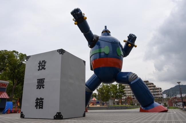 神戸市長田区の鉄人28号モニュメント前に巨大な投票箱を設置。“一票の大きさ”を伝えた。