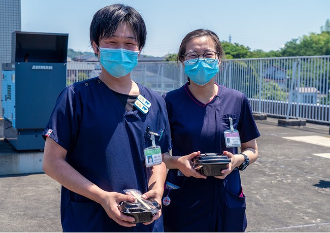 ドローン配送された牛丼を受け取る医療スタッフ