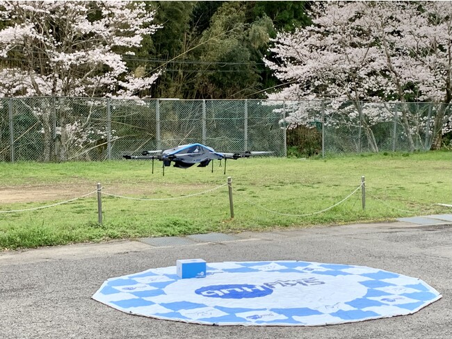 2人分のお弁当とお茶を配送し再度離陸した物流専用ドローン”AirTruck” (佐那河内村保健センター前) 2人分のお弁当とお茶を配送し再度離陸した物流専用ドローン”AirTruck” (佐那河内村保健センター前)