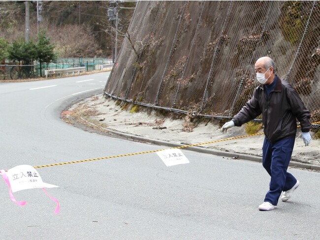 規制線のロープを張る中津川区長 (崩落地点を超えた先の着陸地点) 規制線のロープを張る中津川区長 (崩落地点を超えた先の着陸地点)