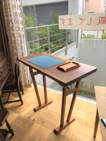 ウォルナット一枚板から生れた立ち机です。脚はお客様のご要望に合せ当社デザイナーがデザインした一品です。