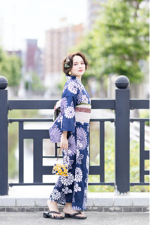 菊を大きくあしらった紺地はクラシカルで上品な雰囲気。綿麻浴衣は着心地抜群でワンランク上の高級感を演出します。