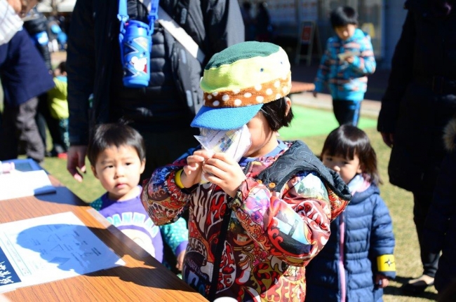 紙食器で水を飲む子ども