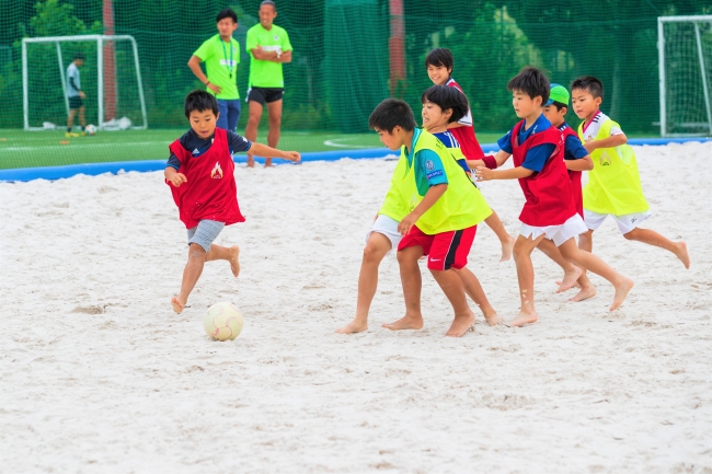 砂上でのサッカーを楽しむ参加者