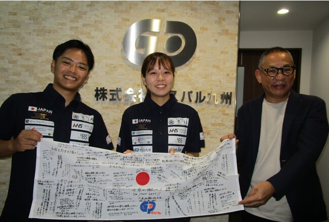 応援メッセージ入り手ぬぐいとともに左から、日本代表大坪さん、田中さん、ガスパル九州社長野坂