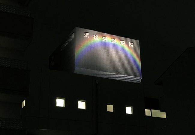 写真２．浜松労災病院の北側看板に投光された虹