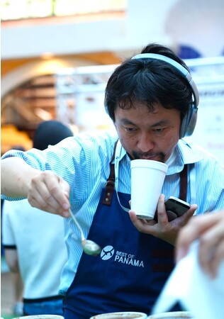 品評会の審査をする鈴木太郎。味覚の数値化に集中するためヘッドフォンをすることが多い。2018年ごろ