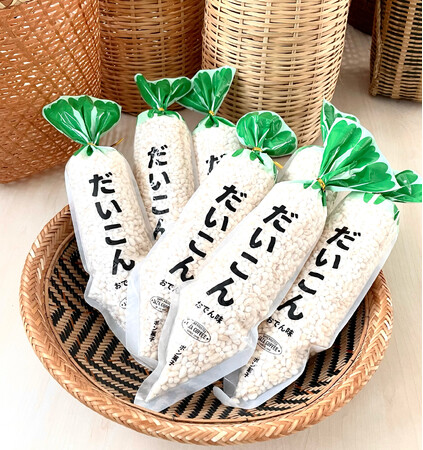 新発売のポン菓子「だいこんおでん味」500円（税込価格）は、普通によく見る、甘い味のポン菓子「にんじん」のサイズが大きい類似品でおにぎり２個分以上の体積がある。