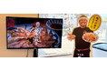 “ジュージュー音”で食欲を刺激　地元の人気店CMを大型モニターで放映開始