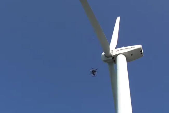 風力発電機の周りを自律飛行で撮影するドローンの様子