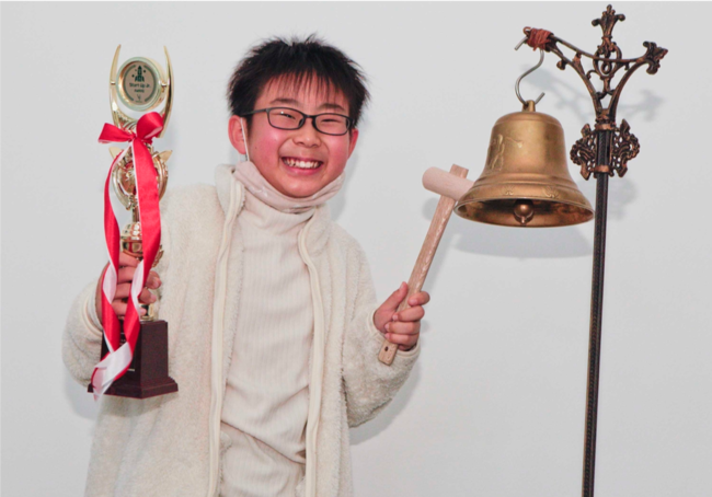 東京証券取引所から貸与された鐘を鳴らす小学生の部大賞の李 禮元さん