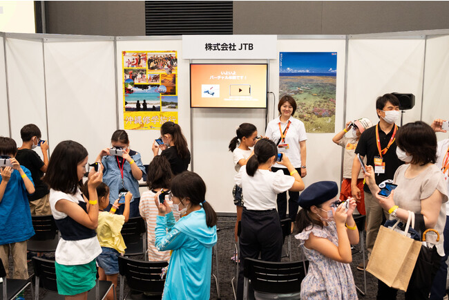 JTBのブースより。VRで沖縄の旅行体験でワクワクする子どもたち