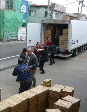 2011年東日本大震災発生後、「やさしい献立」を含めた支援物資を従業員が運び出す様子