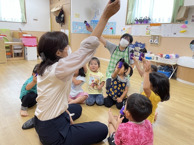 パネルを使って茄子の色やヘタについて説明。手作りの茄子のマラカスはシャカシャカ音が鳴り、子ども達も大喜び