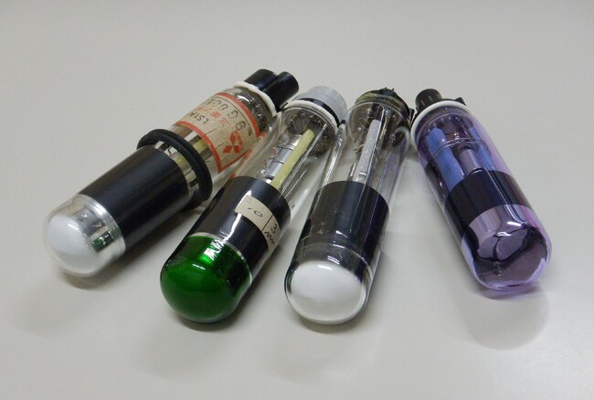 左より、防水パッキン付、ガラス容器着色対応例（緑）、実証試験用、三色一体型の各CRT光源管試作品
