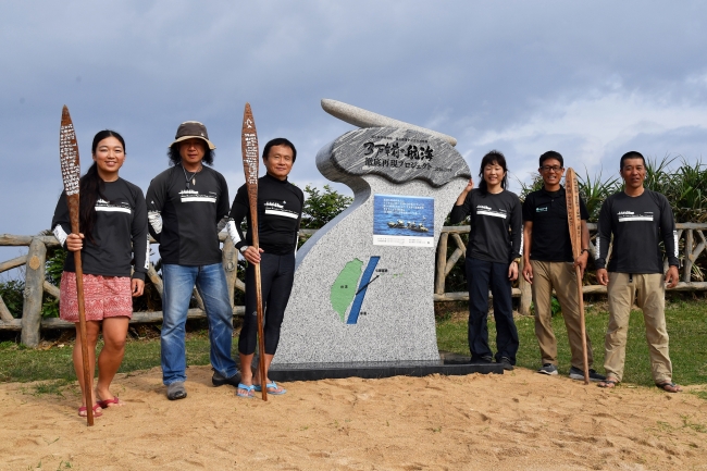 記念碑と丸木舟の漕ぎ手チーム　写真：太田達也