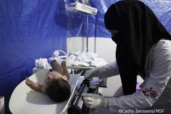 シリアにある仮設病院で新生児の体重を計る助産師