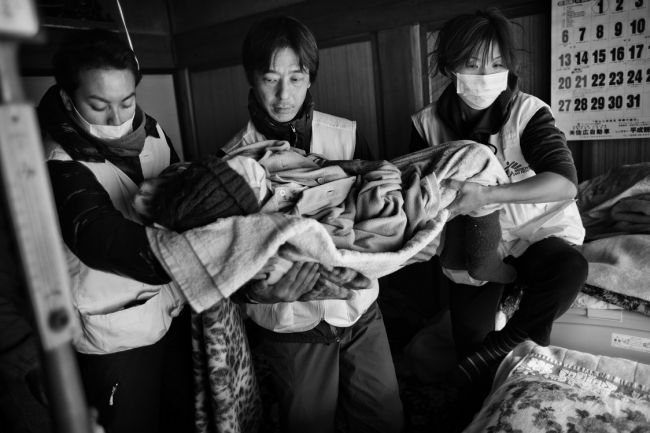  2011年3月23日、宮城県南三陸町の津波被災者に診療を行う加藤医師（中央）