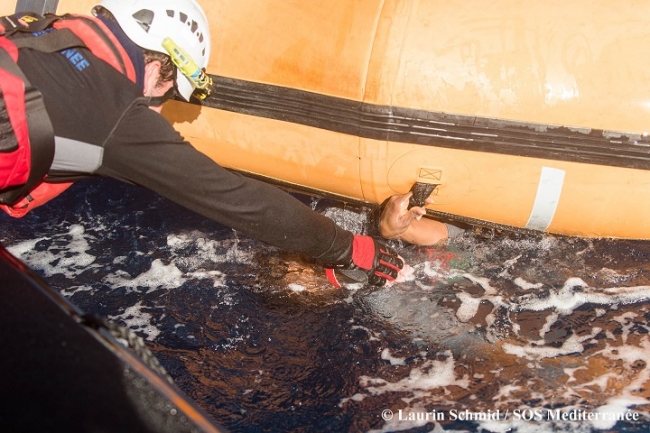 おぼれた人を海中から引っ張り上げる救助スタッフ