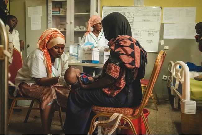 子どもの腕の太さを測定し、栄養状態を確認する保健省のスタッフ＝2022年6月1日　(C) Njiiri Karago／MSF