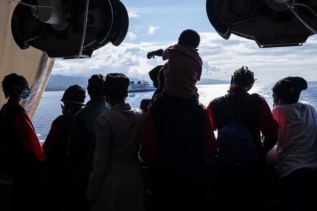 ジオ・バレンツ号の甲板でイタリアの海岸を眺めながら陸への到着に興奮する救助された人びと＝2021年11月19日　(C) Virginie Nguyen Hoang／HUMA
