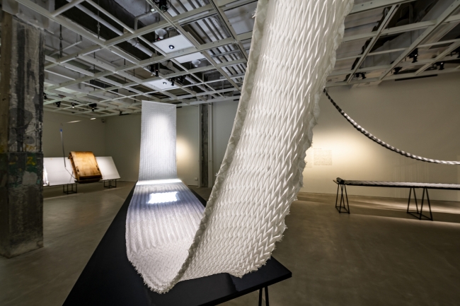 規則正しく折り目を織り込んだ「折り紙織り」の製造工程を再現した展示。（c）CHAT、香港