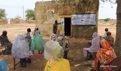 COVID-19のリスクと予防について地域の人々に説明する牧師（スーダン／2020年6月）