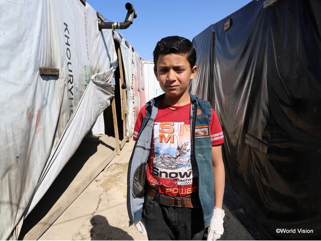 難民キャンプで暮らすシリア難民の少年。狭い場所に簡素なテント小屋がぎっしり並び、生活環境は良くありません