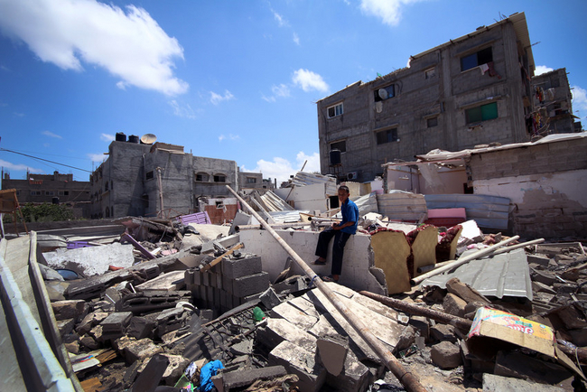破壊された自宅のがれきの上に座る少年（ガザ）©Jozef Nateel / Save the Children