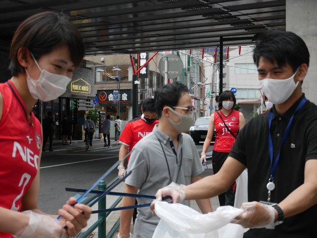 施設関係者とトングを手に地域清掃をする古賀選手