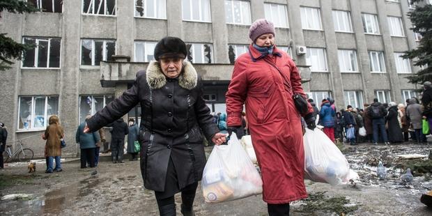 戦闘の最前線、東ウクライナのデバリツェボで人道支援を運ぶ人びと