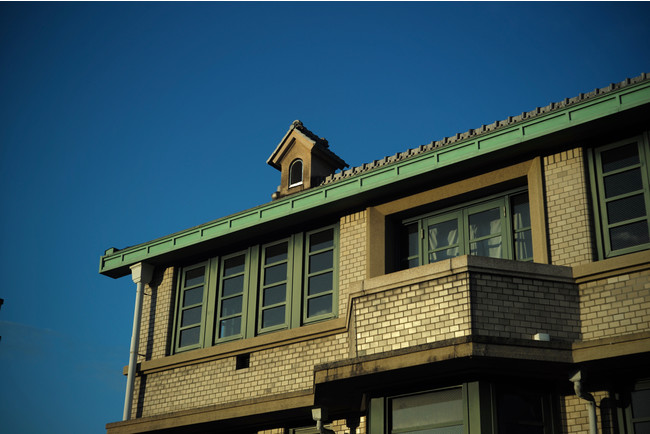 緑色の瓦屋根と外壁のタイルが特徴的な外観