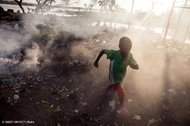 ごみを燃やす煙の中を走る男の子。(マリ)2012年12月撮影(C) UNICEF_UNI134171_Bindra