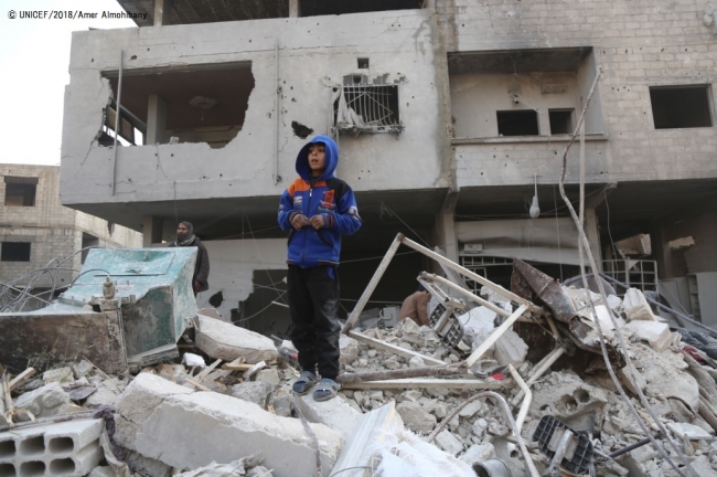 破壊された建物の上に立つ13歳のビラル君。(東グータ) (C) UNICEF_2018_Amer Almohibany