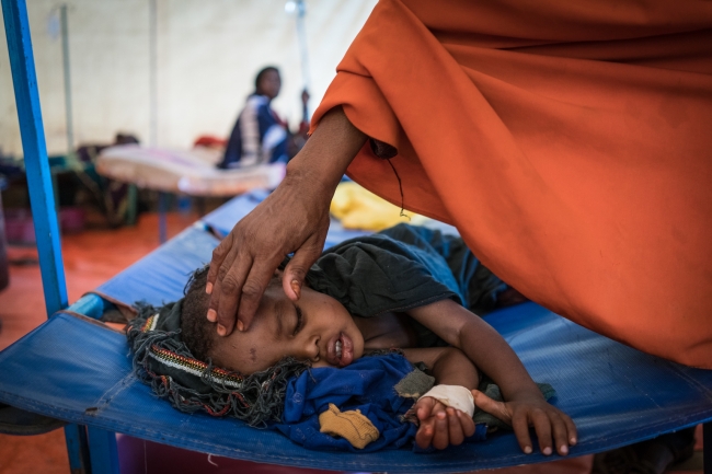 ユニセフが支援するコレラ治療センターで、治療を受ける男の子。頭を撫でるのは母親。（ソマリア、2017年3月3日撮影）© UNICEF_UN061100_Knowles-Coursin