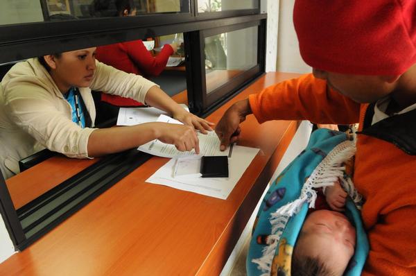 © UNICEF/NYHQ2012-2269/Susan Markisz 出生登録証の発行をする保健員と拇印をする父親（グアテマラ）