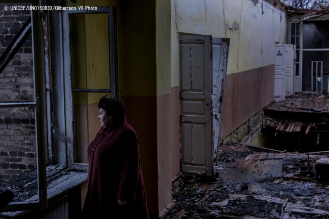 破壊された教室で立ち尽くすElena Mihatskaya校長先生。(2017年11月撮影) © UNICEF_UN0150833_Gilbertson VII Photo