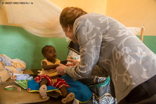 保健センターで赤ちゃんの手を握るヘンリエッタ・フォア事務局長。(2018年5月28日撮影) (C) UNICEF_UN0212603_Keïta
