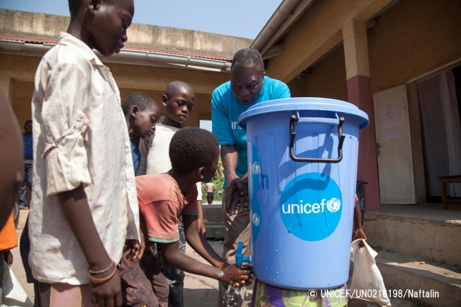 エボラ出血熱の感染予防の重要性をその方法を伝えるため、ユニセフの専門官が学校に赴き、正しい手洗いの方法を子どもたちに伝えている。© UNICEF_UN0216198_Naftalin