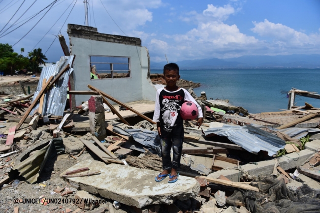波で破壊された自宅の前に立つ、10歳の男の子。（2018年10月3日撮影）© UNICEF_UN0240792_Wilander