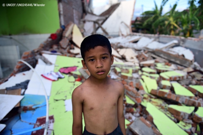 スラウェシ島のパルで、津波によって破壊された建物の前に立つ7歳の男の子。（2018年10月8日撮影）(C) UNICEF_UN0245446_Wilander