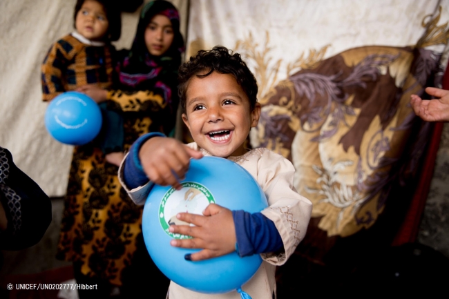 アフガニスタン南部で、ポリオの予防接種後に青い風船をもらって喜ぶ男の子。(2018年3月撮影) (C) UNICEF_UN0202777_Hibbert