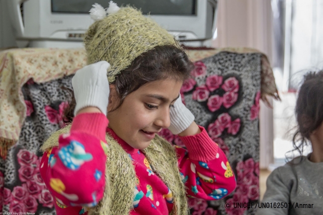 冬用の帽子や服を受け取った子ども（2018年2月撮影）。ユニセフは毎年、難民や国内避難民の子どもたちに冬用衣料などを支援している。© UNICEF_UN0162501_Anmar