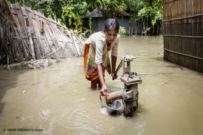 浸水した井戸からきれいな水を汲もうとしている女の子。© UNICEF_UN0286415_Akash
